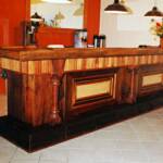 The Twiggs bar is 13 ft long made of 130 year old heart pine with maple accents. The rail is worm-eaten maple. It is magnificent. 
Bar designed by Wil Henry Cobble III.
